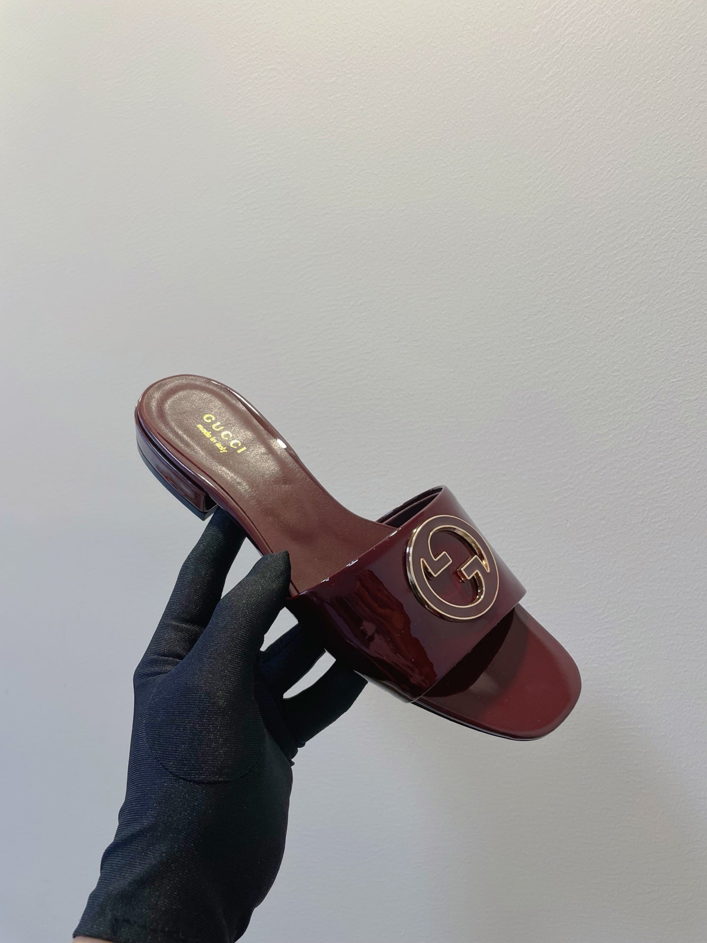 SLIDE SANDALS IN WINE RED GLOSSY SHEEPSKIN ENAMELLED ROUND INTERLOCKING G
